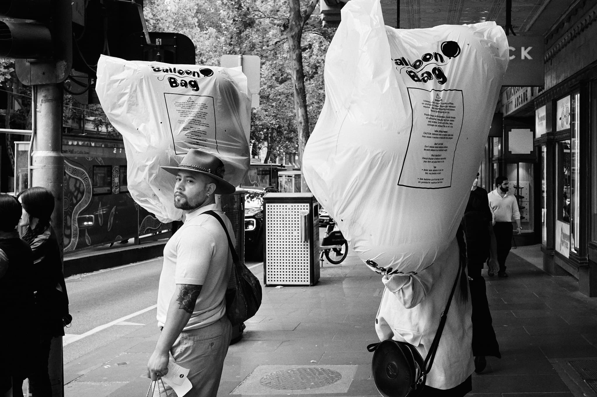 Two people carrying oversized balloon bags, Swanston Street