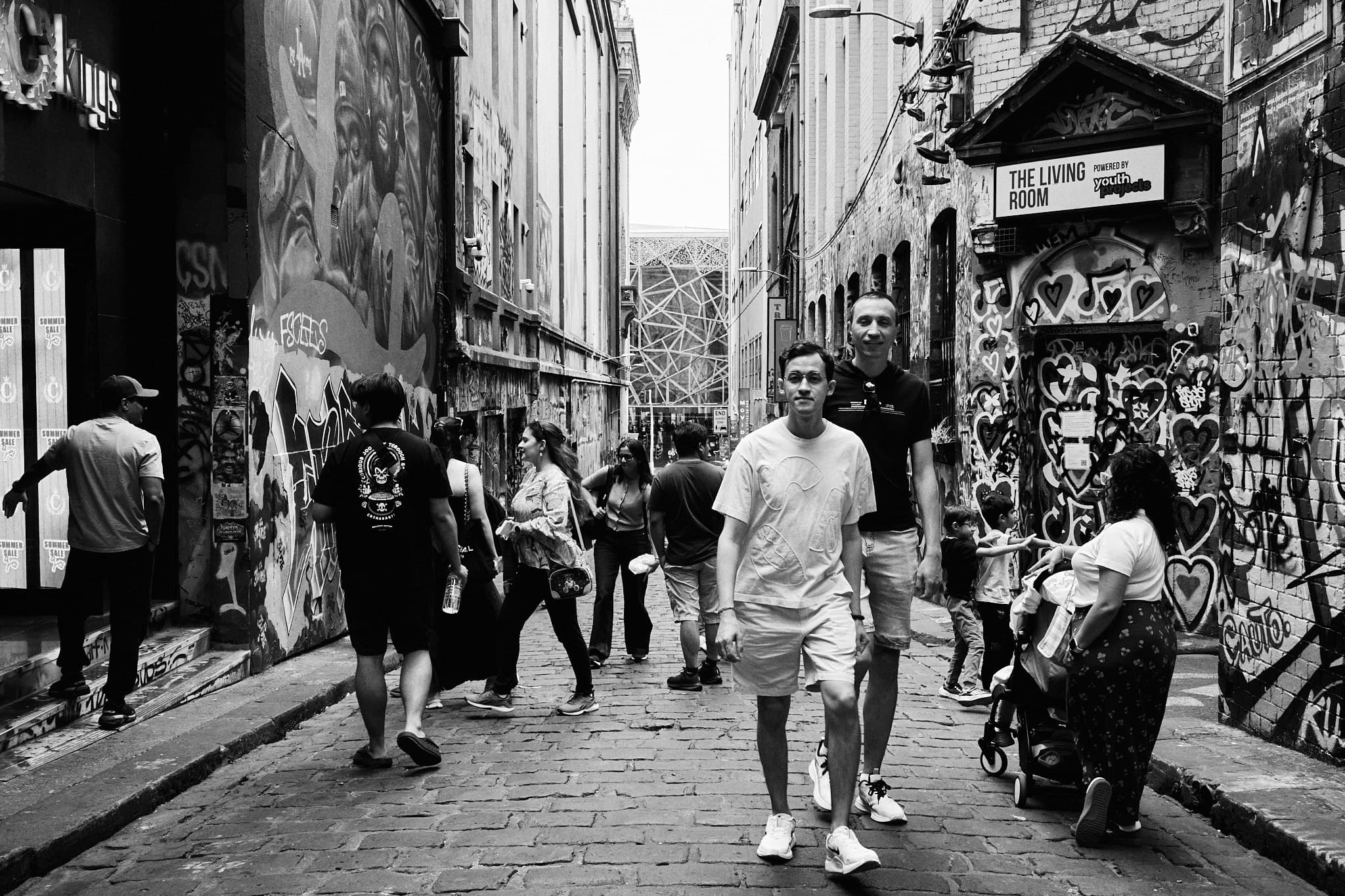 Man in white approaching camera with awareness, Hosier Lane
