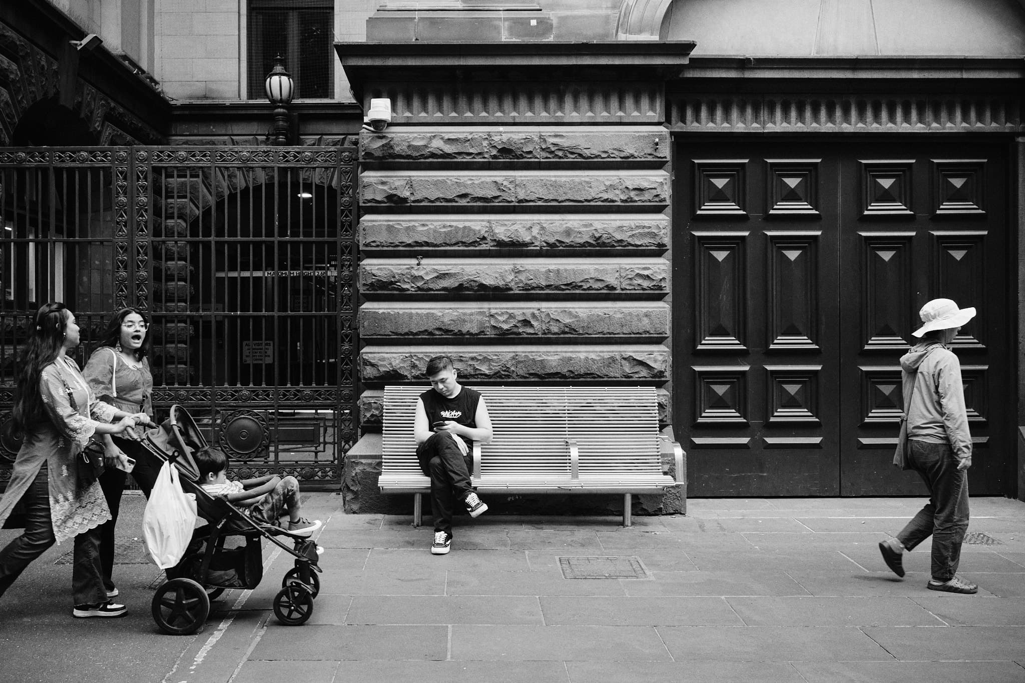 Three stories in one frame - woman laughing, man alone on bench, woman walking past