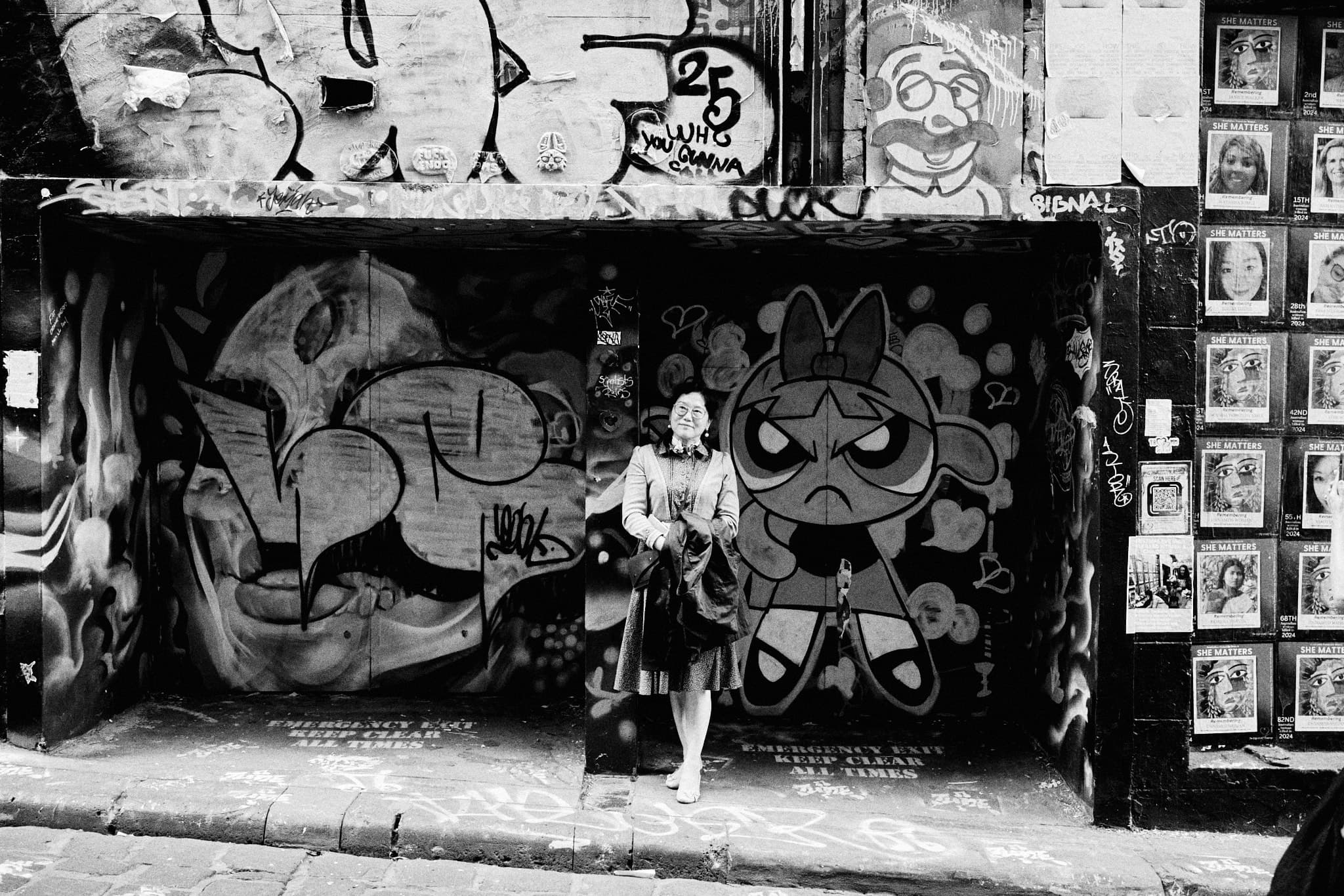 Tourist posing with memorial wall in background, Hosier Lane